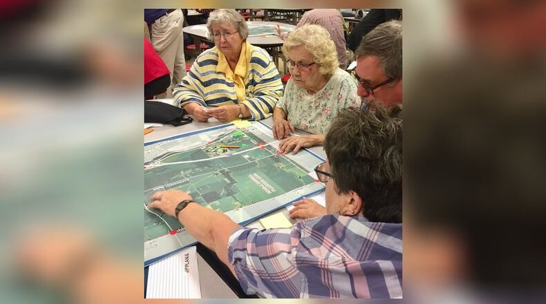 Participants in a community meeting on the study of the County Road 25A corridor between Troy and Piqua review a map of the study area. They were asked to identify the good and not so good features of the area. CONTRIBUTED PHOTO