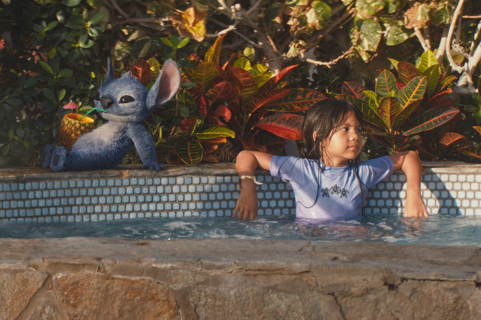 This image released by Disney shows the character Stitch, left, and Maia Kealoha, as Lilo, in a scene from "Lilo & Stitch." (Disney via AP)