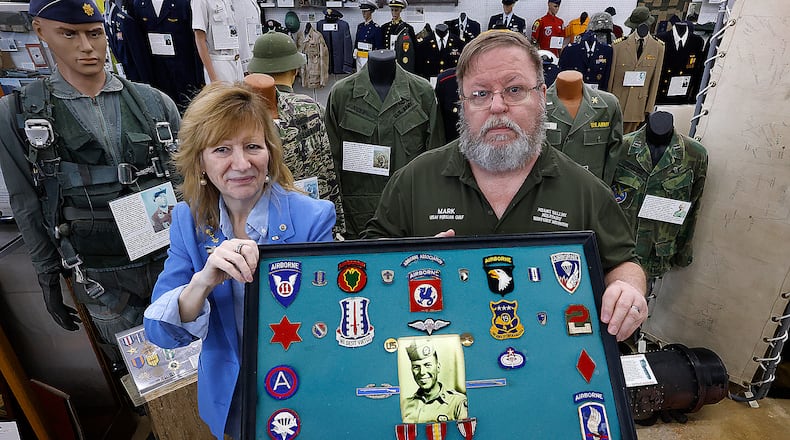 Catherine Beers-Conrad with her husband Mark Conrad proudly hold up one of the displays featuring her father from the Vietnam war at the Miami Valley Military History Museum in Fairborn. The museum is planning a event to mark the 50th anniversary to mark the end of the Vietnam War. MARSHALL GORBY\STAFF