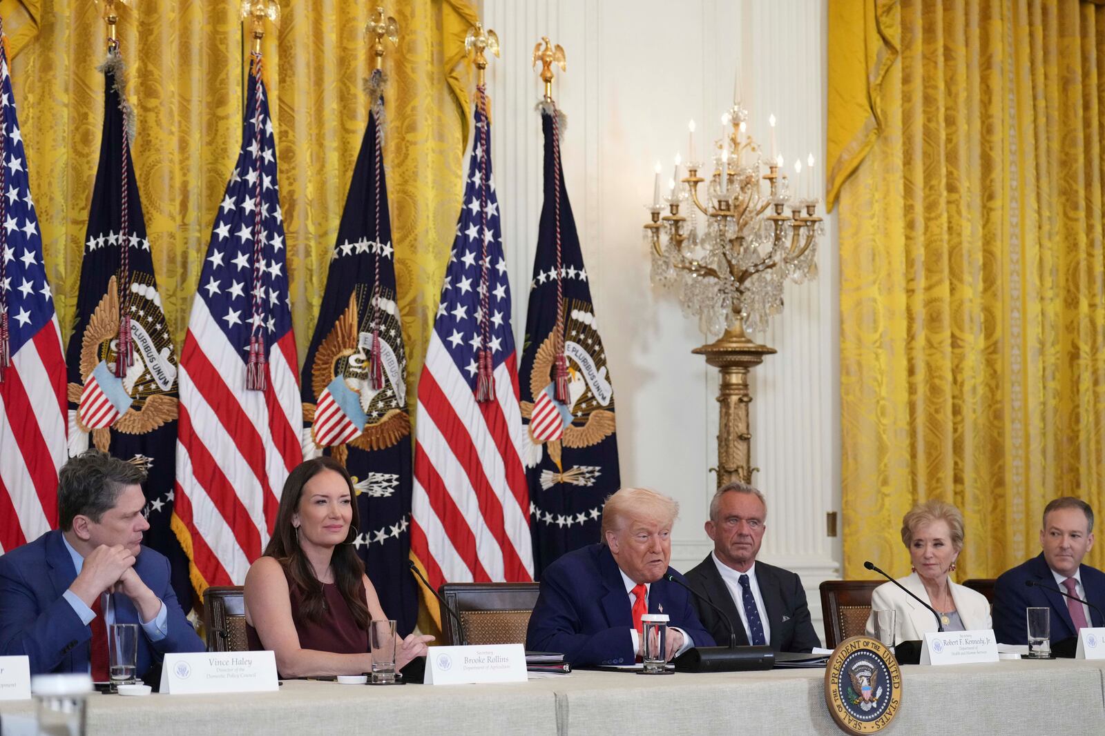 President Donald Trump speaks as Vince Haley, White House director of the Domestic Policy Council, from left, Agriculture Secretary Brooke Rollins, Health and Human Services Secretary Robert F. Kennedy Jr., Education Secretary Linda McMahon and EPA Administrator Lee Zeldin listen during a Make America Healthy Again (MAHA) Commission Event in the East Room of the White House, Thursday, May 22, 2025, in Washington. (AP Photo/Jacquelyn Martin)