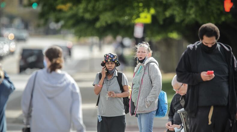 The bus stop at the corner of Brown and Stewart Streets was busy Wednesday October 14, 2020 with people wearing mask and some not wearing.  Dayton Mayor Nan Whaley today said too many people in the city aren’t taking the pandemic seriously and it’s time to get tough to change unsafe behaviors.