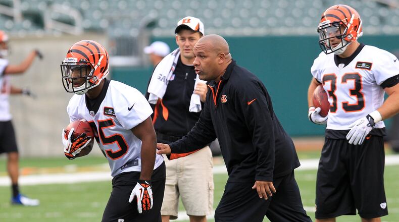 Cincinnati Bengals running back coach Hue Jackson works with rookie Giovani Bernard (25) during day two of rookie minicamp on Saturday, May 11, 2013. NICK DAGGY / STAFF