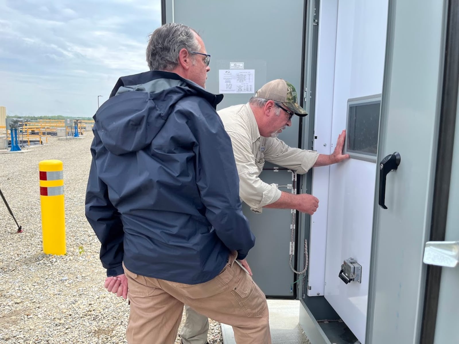 Joseph Ferentz, a remedial program manager on Wright-Patterson Air Force Base, foreground, with Terry Bauer, a Weston Solutions construction quality control manager, checking gauge readings near an Area A water treatment system on June 5, 2025. THOMAS GNAU/STAFF