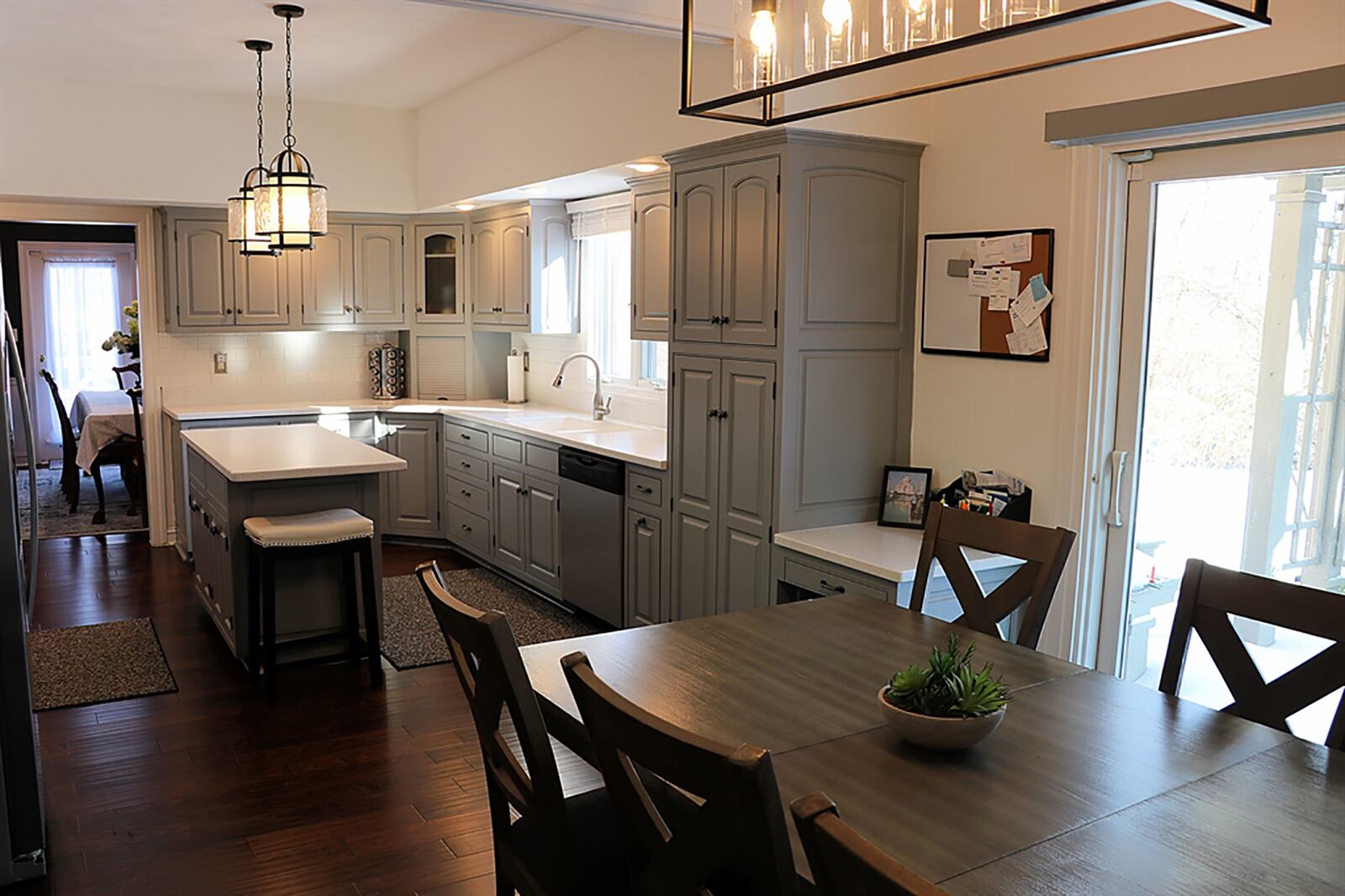 The kitchen’s island has an updated solid-surface countertop that extends to allow breakfast bar seating for two. A window is above the double sink. Refinished cabinetry, with light, solid-surface countertops, covers two walls and surrounds updated appliances. CONTRIBUTED PHOTO BY KATHY TYLER