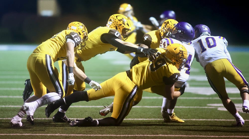 Alter's Wyatt Reifschneider tackles Bellbrook's Christian Burchfield in the first round of the Division III, Region 12 playoffs on Friday, Oct. 31, 2025, at Roush Stadium in Kettering. David Jablonski/Staff