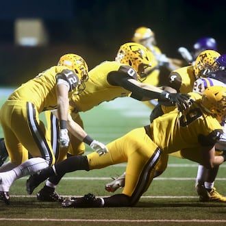 Alter's Wyatt Reifschneider tackles Bellbrook's Christian Burchfield in the first round of the Division III, Region 12 playoffs on Friday, Oct. 31, 2025, at Roush Stadium in Kettering. David Jablonski/Staff