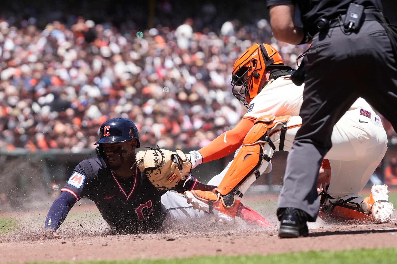 Cleveland Guardians' Angel Martínez, left, is tagged out at home by San Francisco Giants catcher Patrick Bailey during the third inning of a baseball game in San Francisco, Thursday, June 19, 2025. (AP Photo/Jeff Chiu)