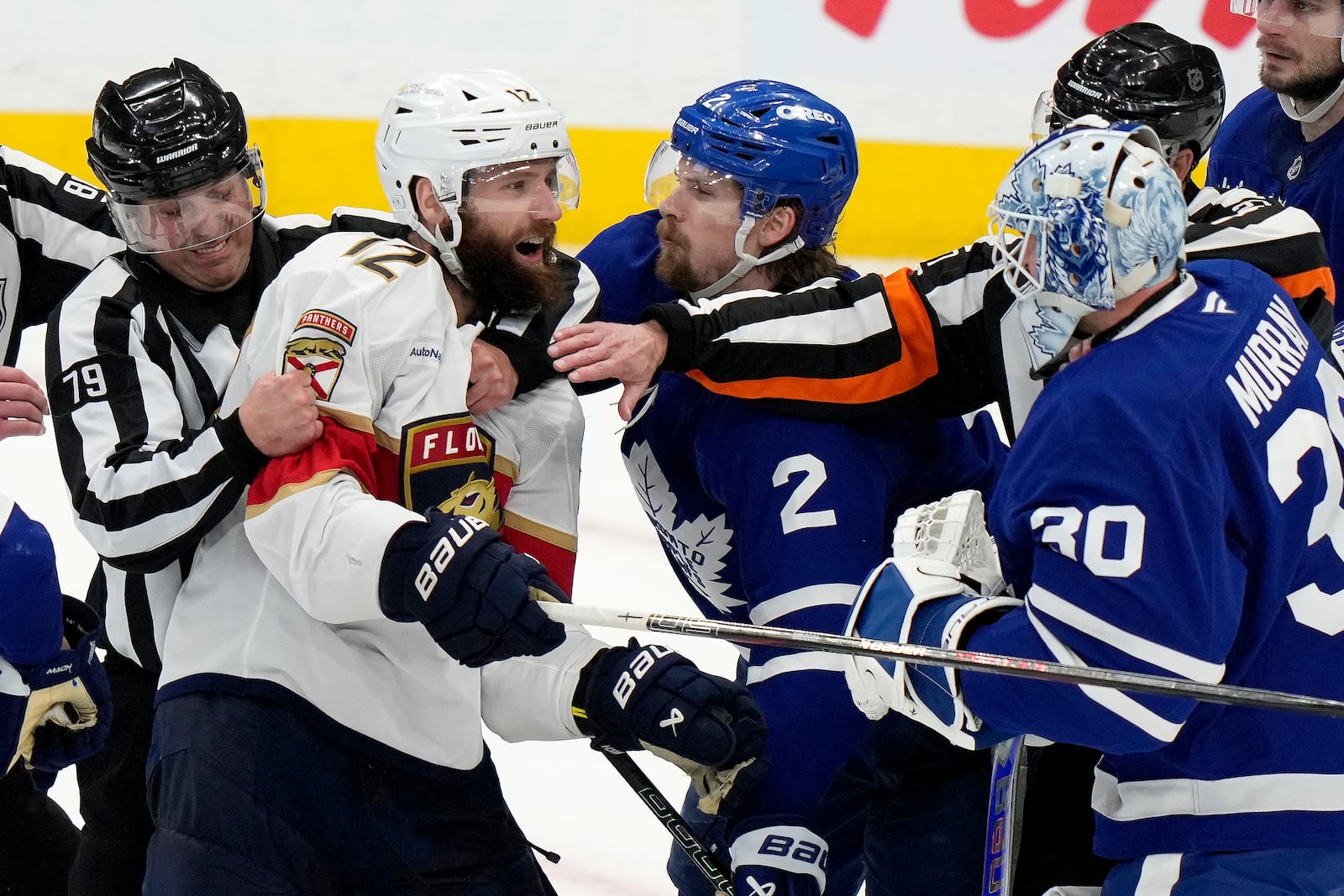 Florida Panthers' Jonah Gadjovich (12) is held back by linesman Kiel Murchison (79) as he goes after Toronto Maple Leafs goaltender Matt Murray (30) during third period NHL playoff hockey action in Toronto on Wednesday, May 14, 2025. (Frank Gunn/The Canadian Press via AP)