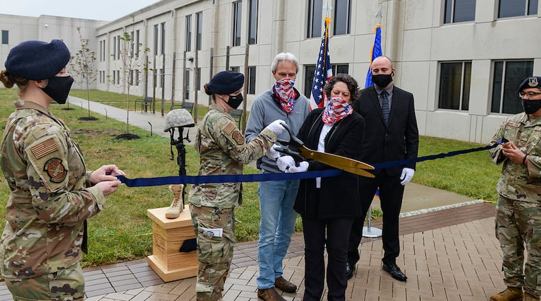 Maj. Julie Roloson, 88th Security Forces commander, and Gold Star family members, Chris Herwick and Don Herwick, cut the ribbon to officially open the Defenders Grove at Wright-Patterson Air Force Base Oct. 21. Defenders Grove is made up of 14 trees, each dedicated to the memory of a fallen 88th Security Forces Squadron Defender who paid the ultimate sacrifice during Operation Iraqi Freedom and Operation Enduring Freedom. A plaque with the name and information of the Defender for whom it’s dedicated is located beside each tree. U.S. AIR FORCE PHOTO/WESLEY FARNSWORTH