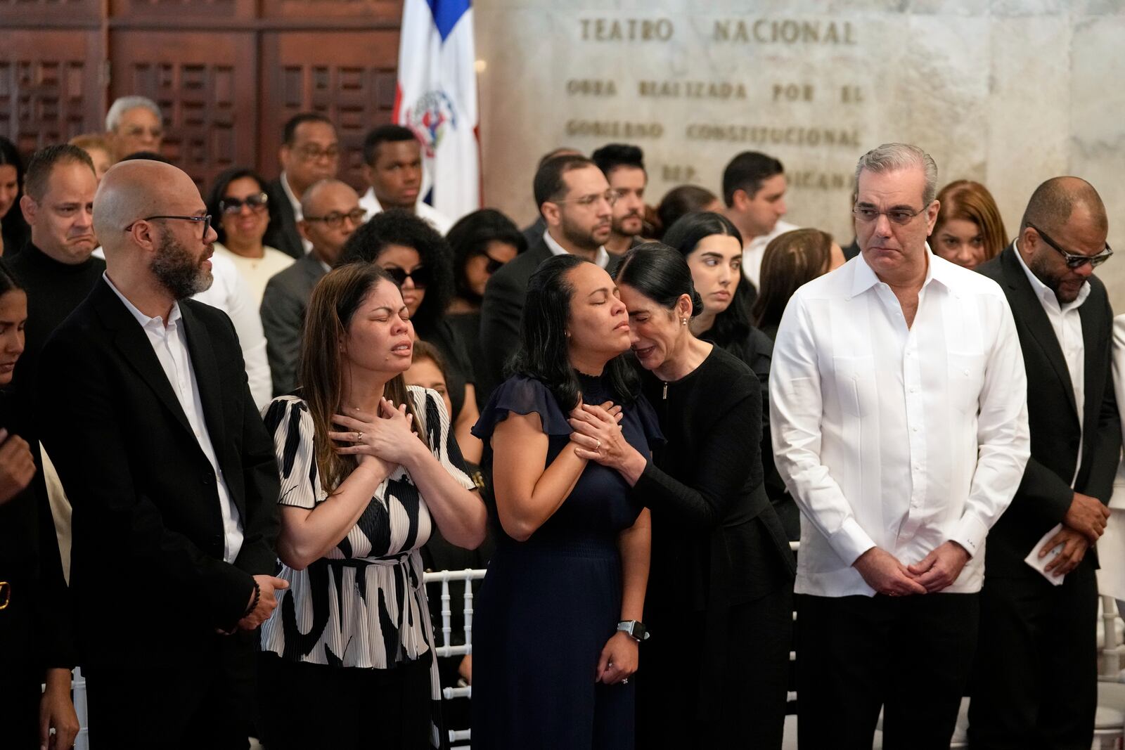 Dominican Republic President Luis Abinader, second from right, and his wife Raquel Arbaje Soni, third from right, attends the wake of Dominican singer Rubby Perez who died in the roof collapse at the Jet Set nightclub during his merengue concert, at the Eduardo Brito National Theater in Santo Domingo, Dominican Republic, Thursday, April 10, 2025. (AP Photo/Matias Delacroix)