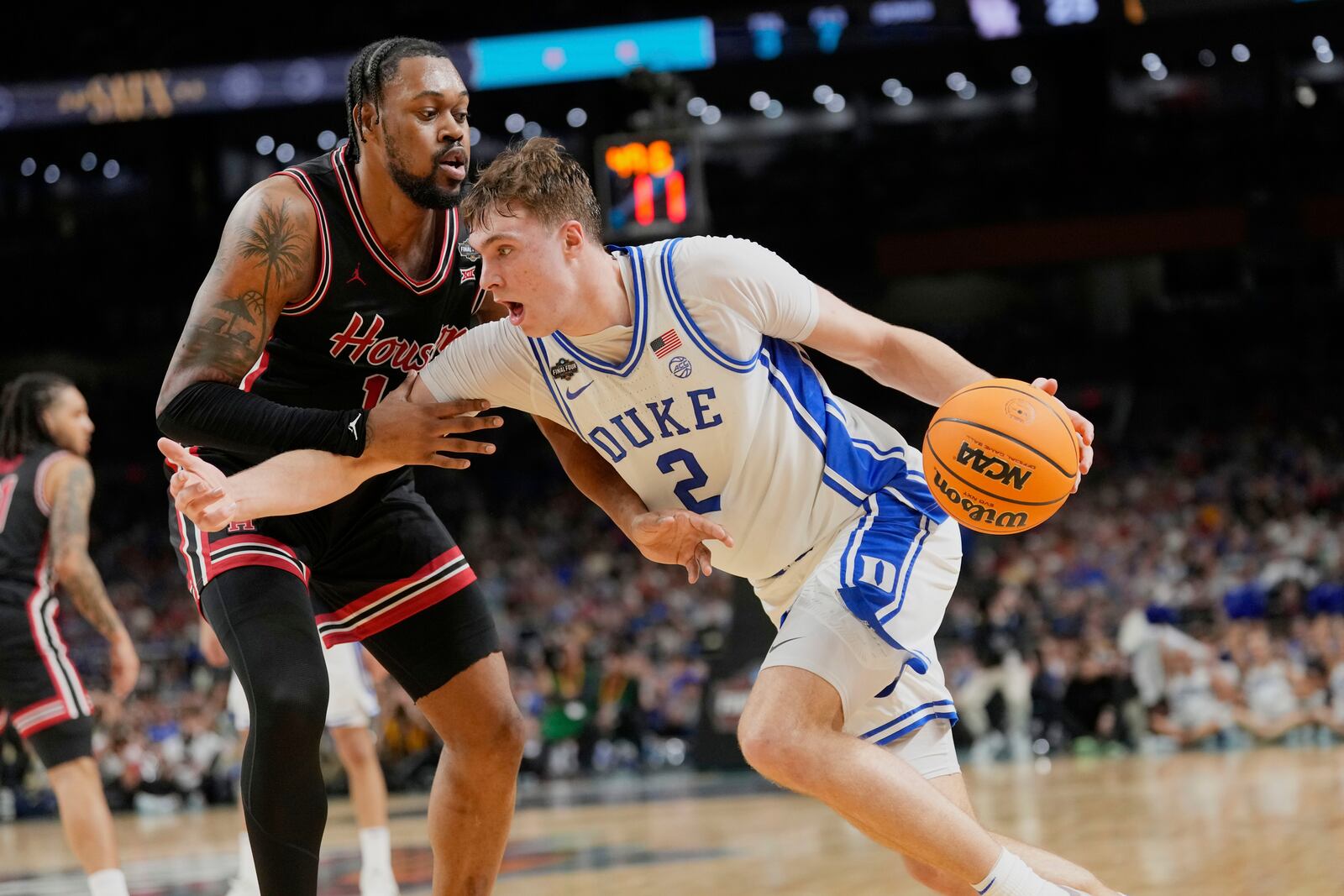 Duke's Cooper Flagg (2) drives to the basket as Houston's J'Wan Roberts defends during the first half in the national semifinals at the Final Four of the NCAA college basketball tournament, Saturday, April 5, 2025, in San Antonio. (AP Photo/Eric Gay)