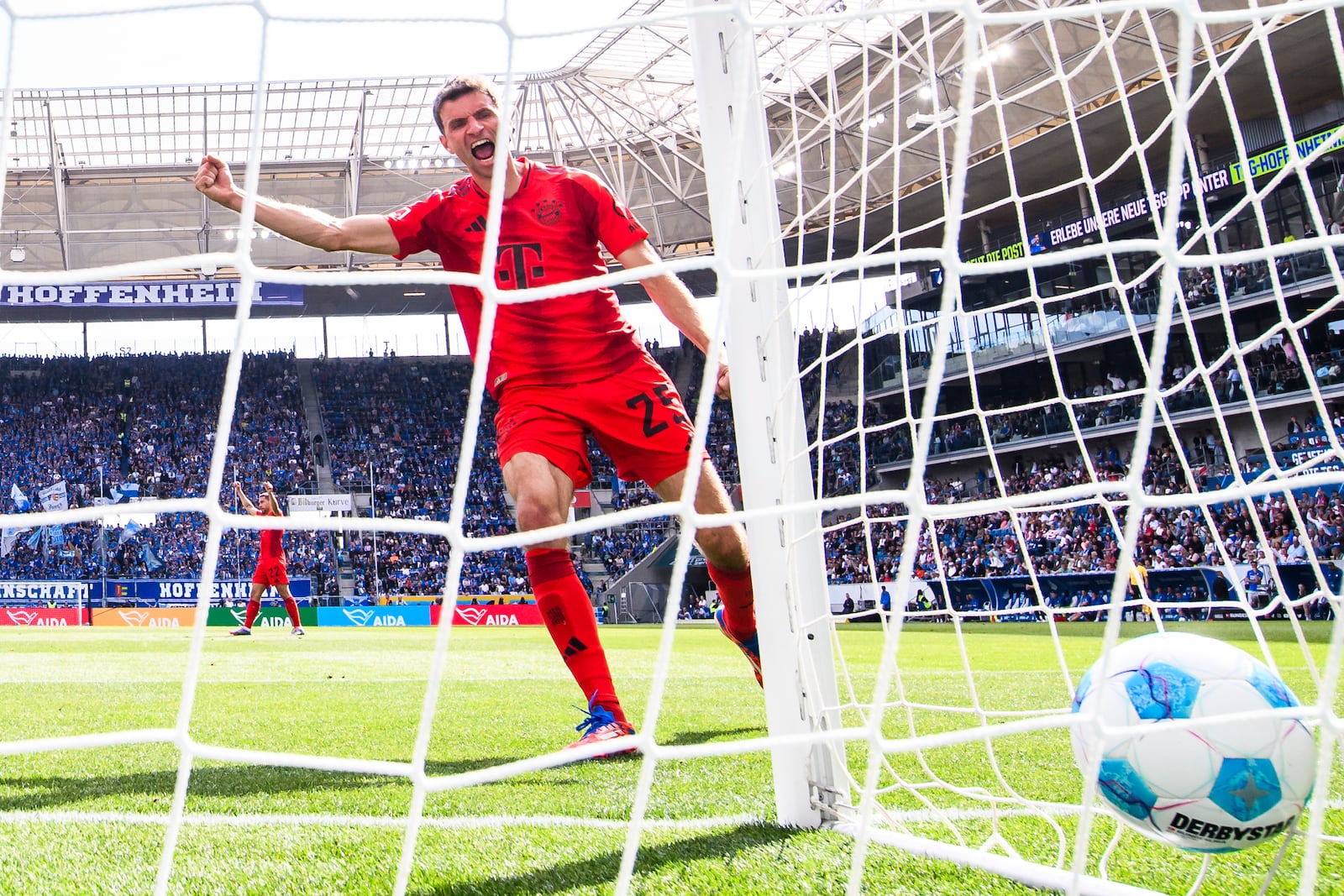 Bayern's Thomas Mueller celebrates after his team's second goal during the German Bundesliga soccer match between TSG 1899 Hoffenheim and Bayern Munich at the PreZero Arena in Sinsheim, Germany, Saturday, May 17, 2025. (Tom Weller/dpa via AP)