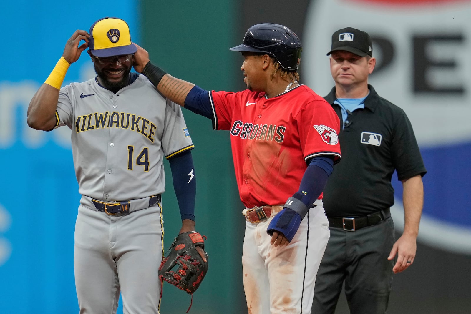 Cleveland Guardians' Jose Ramirez, center, talks with Milwaukee Brewers shortstop Andruw Monasterio (14) after advancing to second base on a wild pitch by pitcher Freddy Peralta in the sixth inning of a baseball game in Cleveland, Monday, May 12, 2025. (AP Photo/Sue Ogrocki)