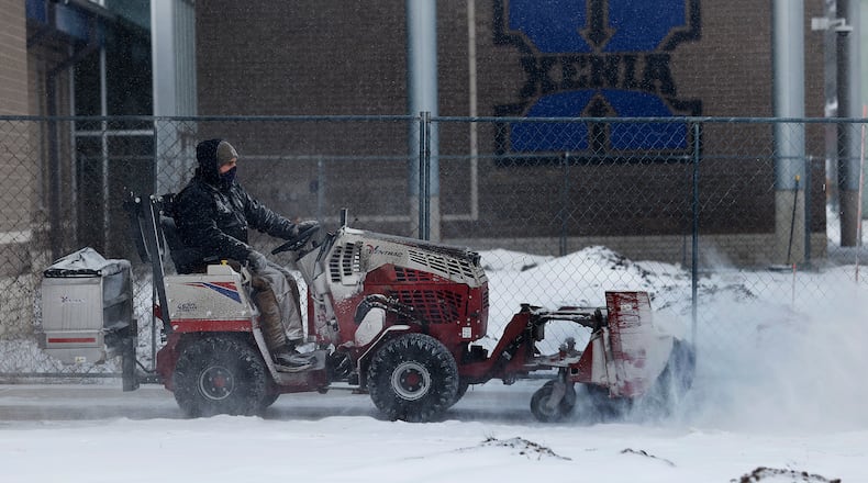 With the severe cold weather most schools were closed Thusday, Jan. 21, 2025. Xenia city schools were on a two hour delay.  A man removes snow from the sidewalks at the new  Warner Middle School. MARSHALL GORBY\STAFF