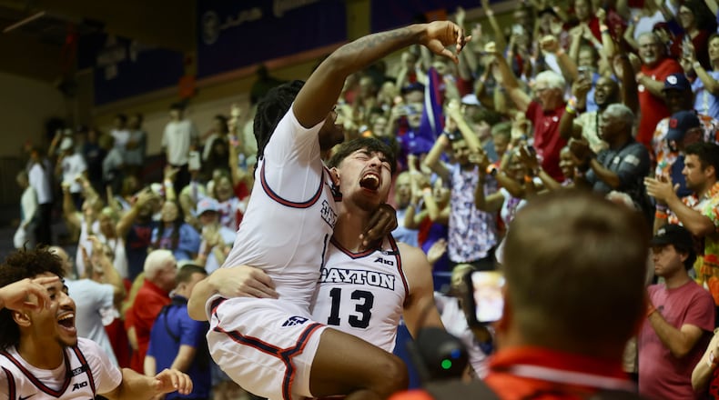 Dayton's Isaac Jack carries Malachi Smith off the court after a victory against Connecticut in the Maui Invitational on Wednesday, Nov. 27, 2024, at the Lahaina Civic Center. David Jablonski/Staff