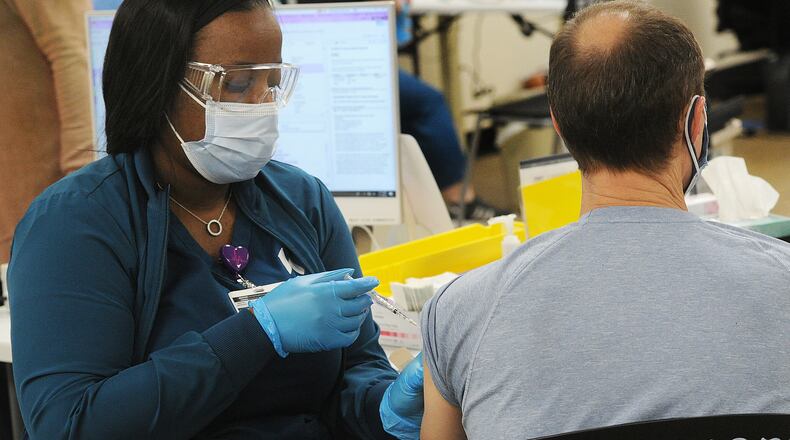 Kettering Health Network, medical assistant, Sonya Scott administers a COVID-19 vaccine at Greene Memorial Hospital, Thursday, March 11, 2021. MARSHALL GORBY\STAFF