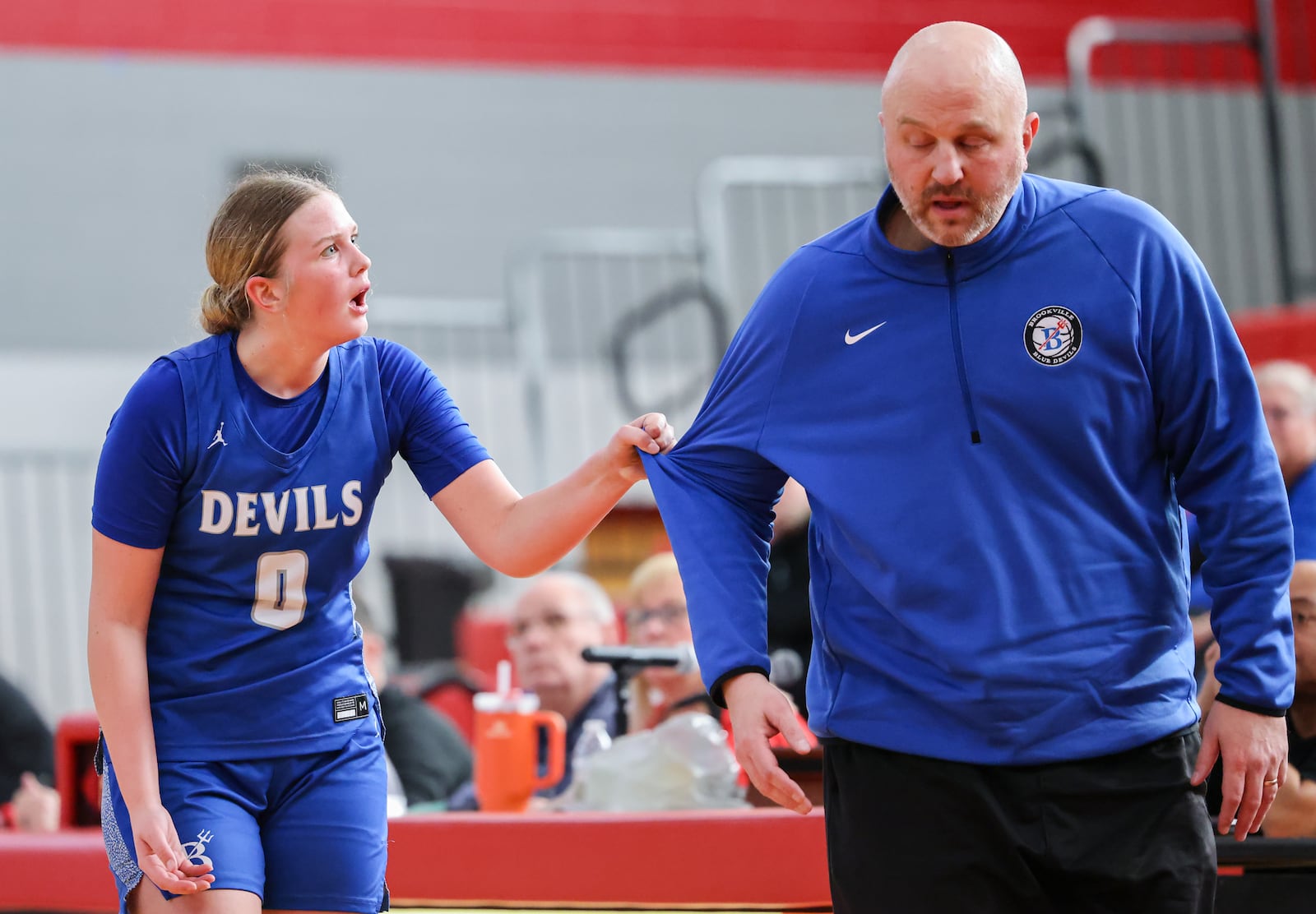 Brookville sophomore guard Jolie Gudorf talks to assistant coach Dan Gudorf in the third quarter of a Division IV district final on Saturday, Feb. 28 at Troy High School's Trojan Activities Center. Gudorf led the Blue Devils with 25 points. BRYANT BILLING / STAFF