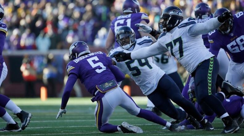 Minnesota Vikings quarterback Teddy Bridgewater (5) is brought down by Seattle Seahawks linebacker Bobby Wagner (54) and defensive tackle Ahtyba Rubin (77) during the second half of an NFL wild-card football game, Sunday, Jan. 10, 2016, in Minneapolis. (AP Photo/Nam Y. Huh)