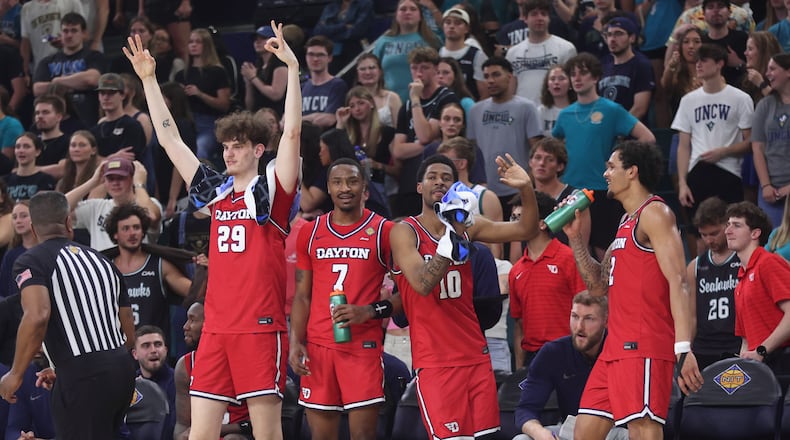 Dayton players react after a 3-pointer by Malcolm Thomas in the final minutes against North Carolina Wilmington in the first round of the National Invitation Tournament on Saturday, March 21, 2026, at Trask Coliseum in Wilmington, N.C.. David Jablonski/Staff
