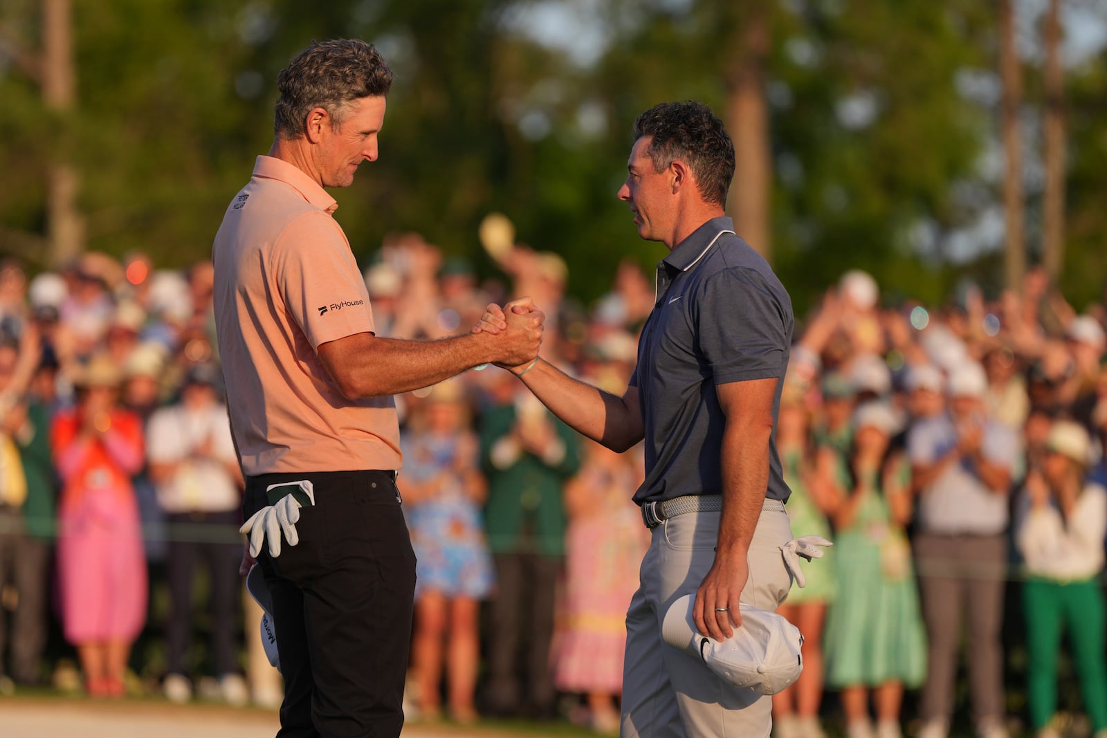 Rory McIlroy, of Northern Ireland, right, greets Justin Rose, of England, after winning in a playoff after the final round the Masters golf tournament, Sunday, April 13, 2025, in Augusta, Ga. (AP Photo/Matt Slocum)
