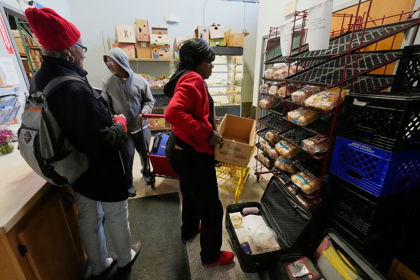 People collect food staples at the Bishop Sullivan Center food pantry, Tuesday, April 15, 2025, in Kansas City, Mo. (AP Photo/Charlie Riedel)