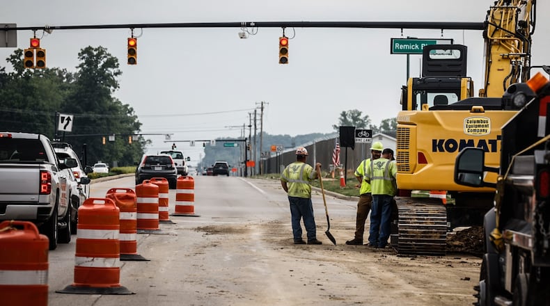 Workers are adding a turn lane at the intersection of Ohio 741 and Remick Boulevard in Springboro. JIM NOELKER/STAFF