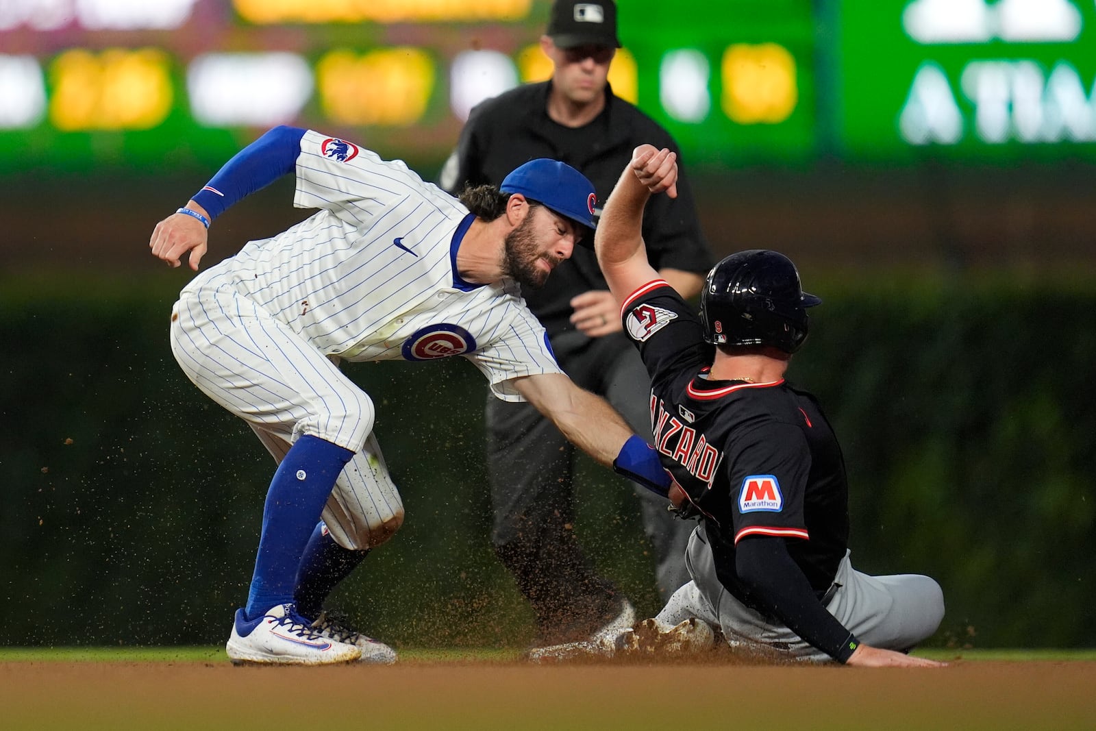 Cleveland Guardians designated hitter Kyle Manzardo, right, is caught stealing second by Chicago Cubs shortstop Dansby Swanson, left, during the sixth inning of a baseball game Thursday, July 3, 2025, in Chicago. (AP Photo/Erin Hooley)