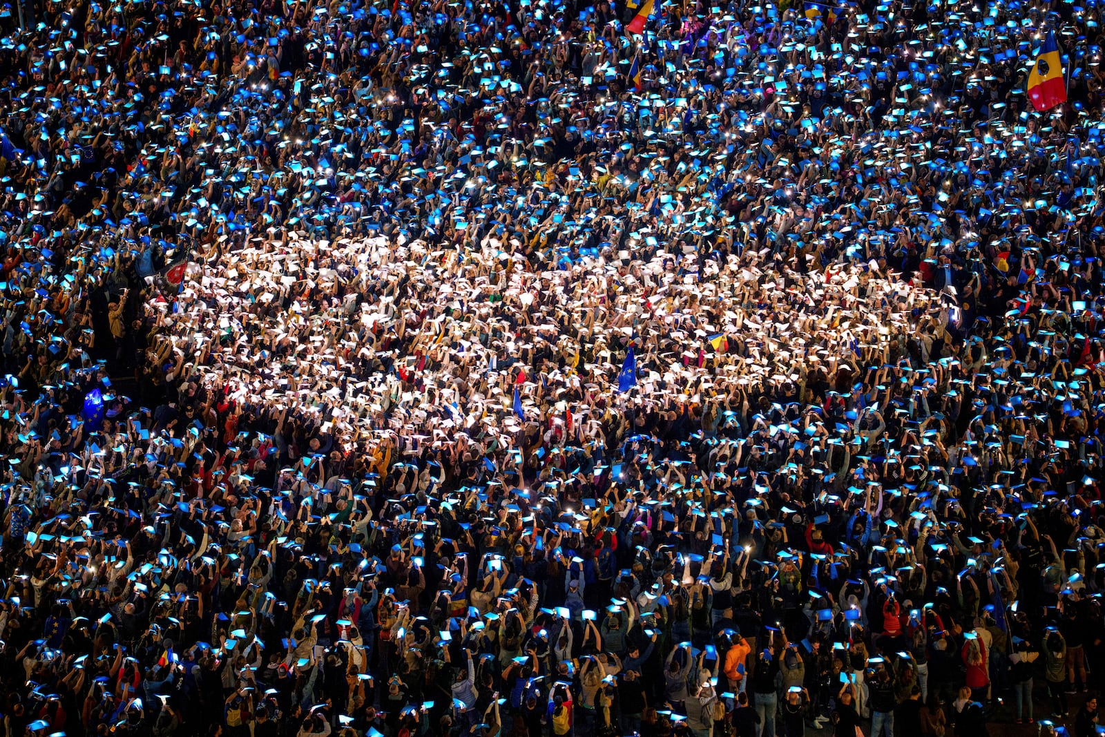FILE - People shine lights behind coloured papers attempting to make a heart shape during a pro-European rally, joined by thousands, to counter what the organizers described as a "wave of sovereignism and ultranationalism", outside the government headquarters in Bucharest, Romania, Saturday, March 15, 2025. (AP Photo/Andreea Alexandru, File)