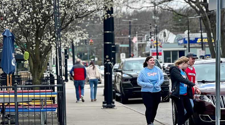 A group of Dayton Flyers fans leave a restaurant on Brown Street soon after the team's NCAA game loss on Saturday. AIMEE HANCOCK/STAFF
