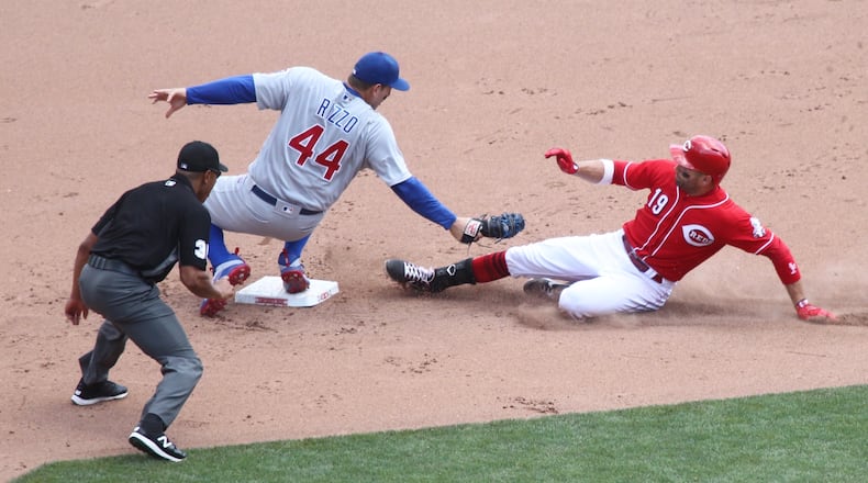 The Reds' Joey Votto slides into second safely after driving in the go-ahead run in the seventh inning as the Cubs' Anthony Rizzo applies the late tag on Sunday, June 24, 2018, at Great American Ball Park in Cincinnati. David Jablonski/Staff