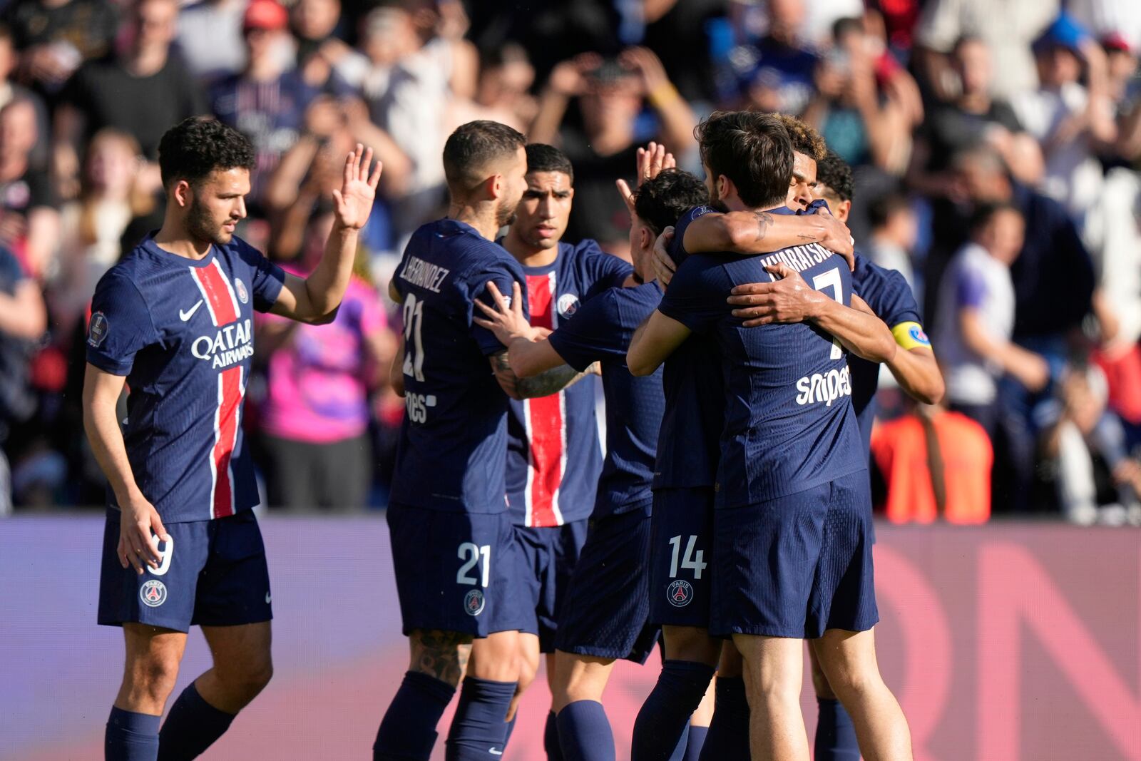 Paris Saint-Germain players celebrate after PSG's Desire Doue scored his side's opening goal during the French League One soccer match between Paris Saint-Germain and Angers at Parc des Princes stadium in Paris, Saturday, April 5, 2025. (AP Photo/Michel Euler)