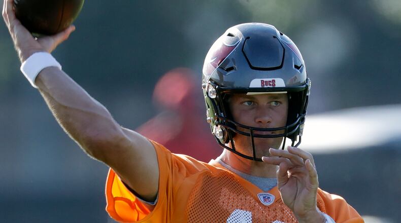 FILE - Tampa Bay Buccaneers quarterback Tom Brady (12) throws during an NFL football organized team activity Thursday, Aug. 13, 2020, in Tampa, Fla. Tom Brady has shifted the NFC South spotlight to Tampa Bay, but Drew Brees and the New Orleans Saints are still the three-time defending division champions. The battle of the NFL’s all-time leading passers brings extra drama to the division race. (AP Photo/Chris O'Meara, File)
