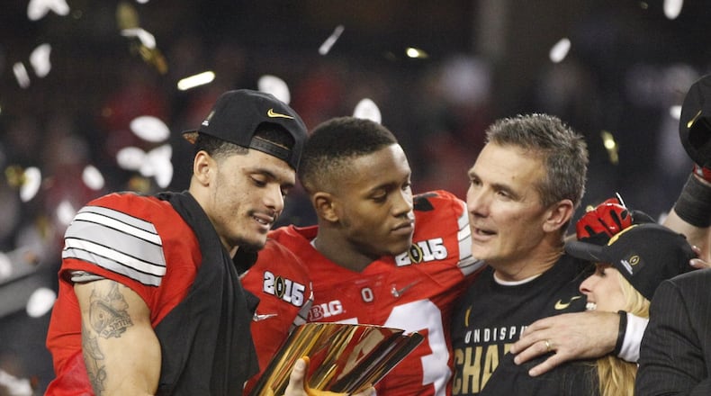 Ohio State’s Devin Smith, left, Darron Lee, Urban Meyer and his wife Shelley, far right, celebrate after a victory against Oregon in the national championship game on Monday, Jan. 12, 2015, at AT&T Stadium in Arlington, Texas. David Jablonski/Staff