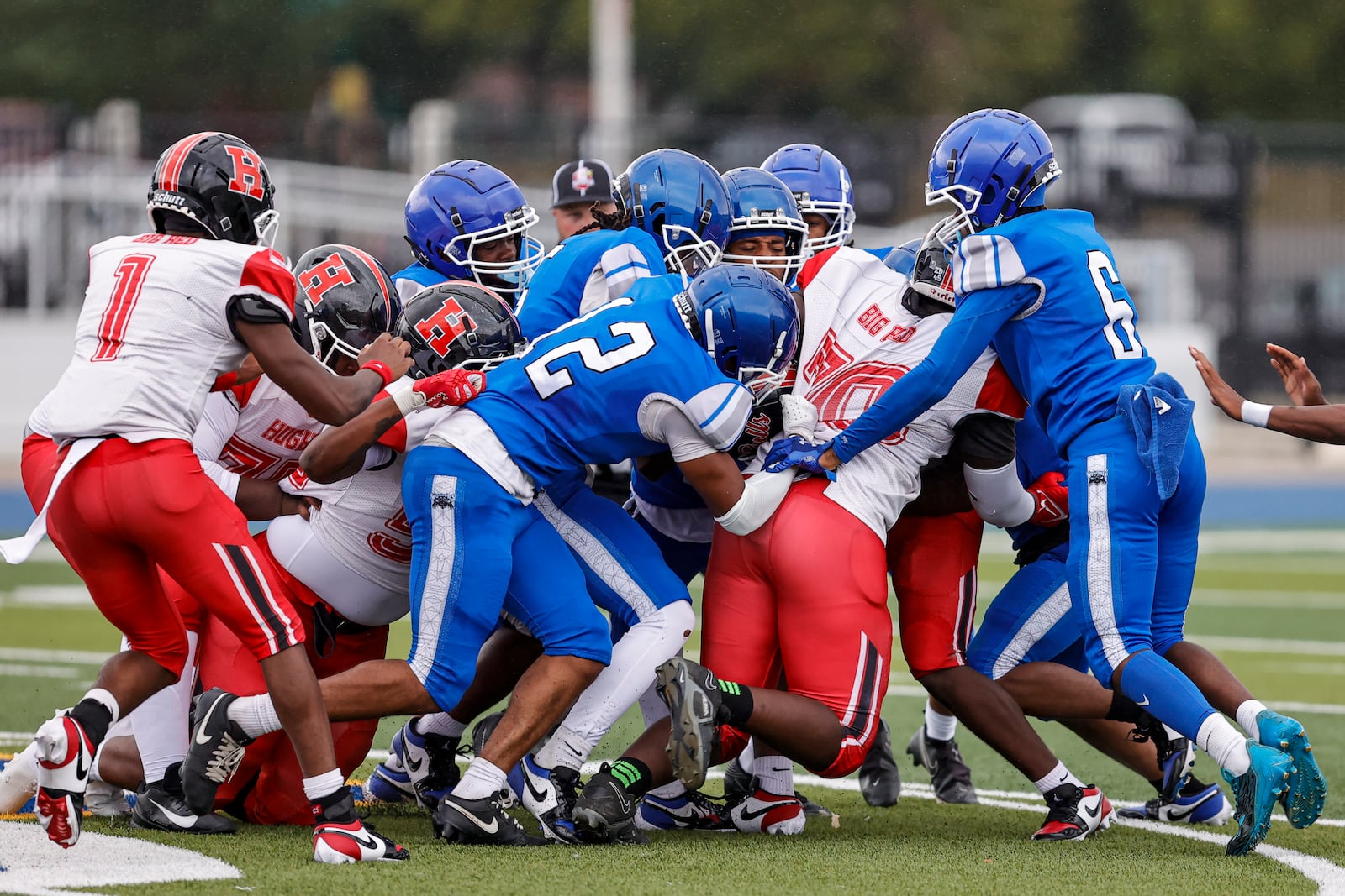 A group of Dunbar High School defenders bring down Hughes sophomore Nehemiah Engleman during their game on Thursday, Aug. 21 at Welcome Stadium. MICHAEL COOPER / STAFF