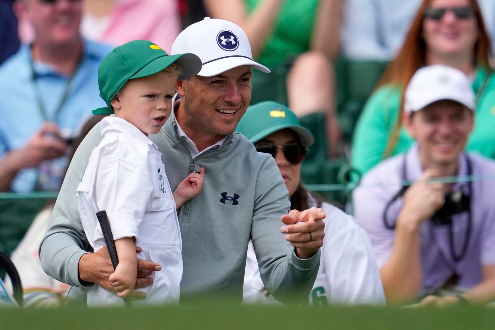 Jordan Spieth interacts with son Sammy during the par-3 contest at the Masters golf tournament, Wednesday, April 9, 2025, in Augusta, Ga. (AP Photo/George Walker IV)