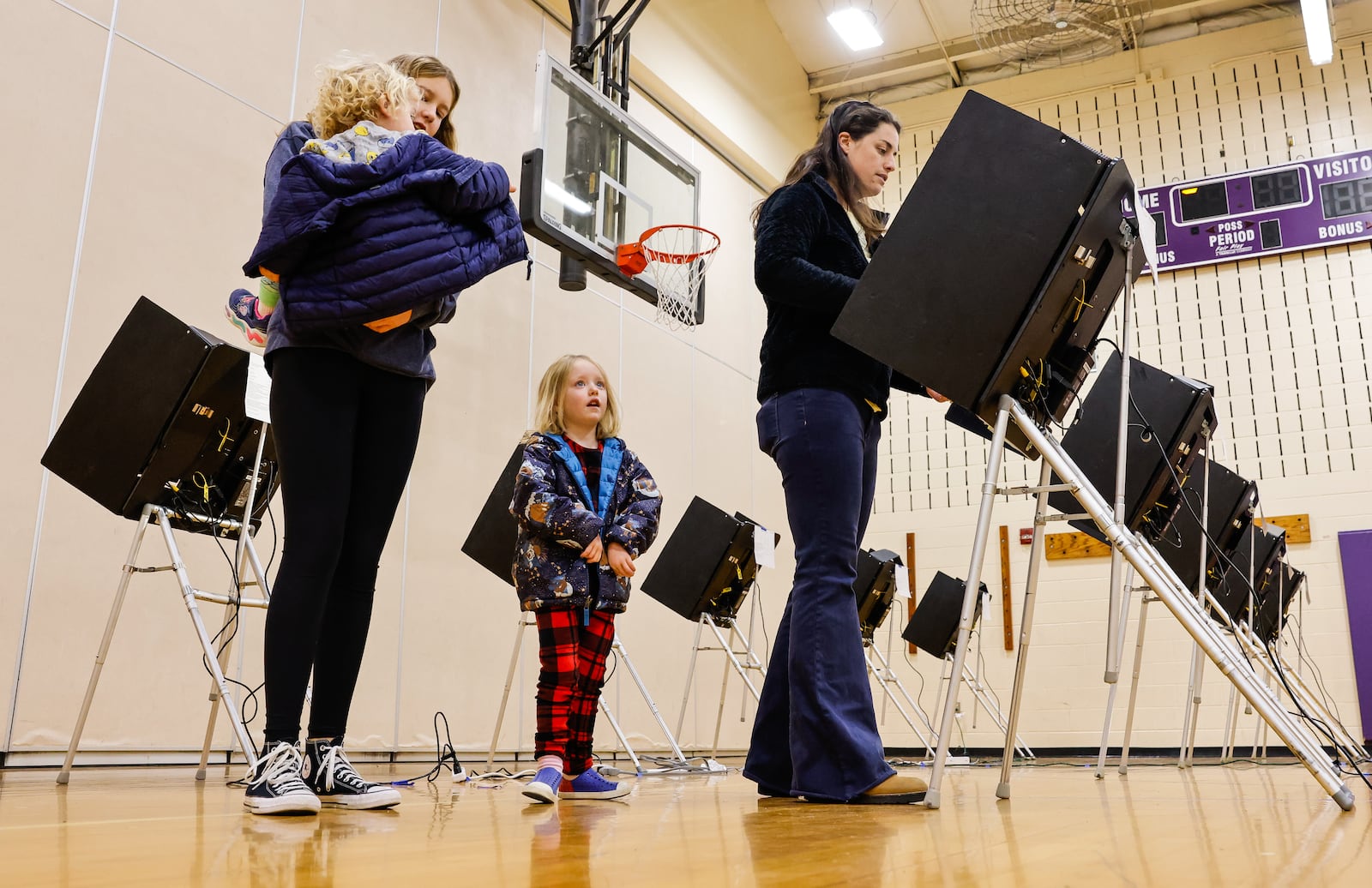 Attie Kempf-Marshall votes, with Harper Marshall, 13, Brad Marshall, 2, and Lettie Marshall, 4, by her side, at the polling location in the gymnasium of Creekview Elementary School Tuesday, Nov. 4, 2025 in Middletown. NICK GRAHAM/STAFF