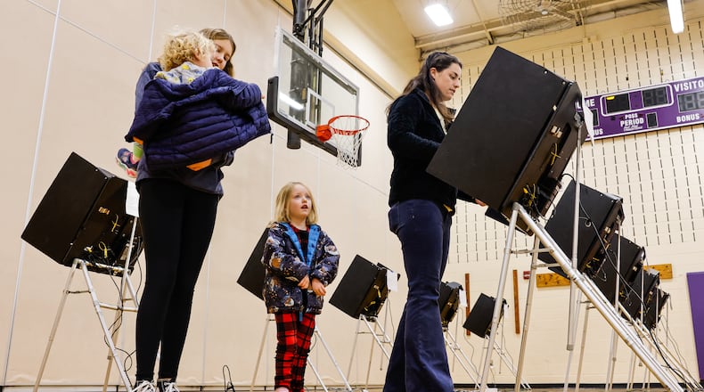 Nearly 30% of registered Butler County voters either cast an early vote or turned out on Election Day. Pictured is Attie Kempf-Marshall casting a vote, with Harper Marshall, 13, Brad Marshall, 2, and Lettie Marshall, 4, by her side on Election Day, Tuesday, Nov. 4, 2025. They were at the Creekview Elementary School polling location in Middletown. NICK GRAHAM/STAFF
