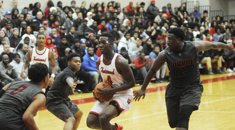 Trotwood’s Myles Belyeu is surrounded by Wayne’s Rashad McKee (left), Ronnie Hampton and Antwuan Johnson. Wayne defeated host Trotwood-Madison 90-87 in double-OT last month. Both teams will play in the upcoming 16th annual Premier Health Flyin’ to the Hoop. MARC PENDLETON / STAFF