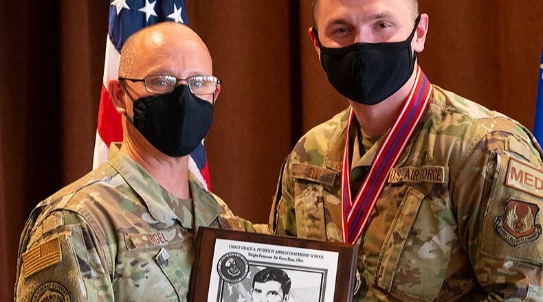 Chief Master Sgt. Theodore Angel (left), of the Air Force Life Cycle Management Center’s Aircrew Performance Branch, presents Staff Sgt. Kenneth Ellis, 88th Healthcare Operations Squadron, with the John L. Levitow Award during the Airman Leadership School graduation Oct. 14 in the Wright-Patterson Club. The Levitow Award, which goes to the top graduate, is the Air Force’s highest honor for enlisted professional military education and presented to the student who demonstrates the most outstanding leadership and scholastic achievement. U.S. AIR FORCE PHOTO/R.J. ORIEZ