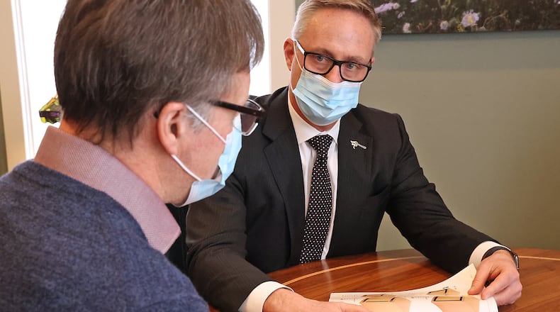 Rob Rue, owner of Littleton & Rue Funeral Home, goes over funeral details with a client Friday. BILL LACKEY/STAFF