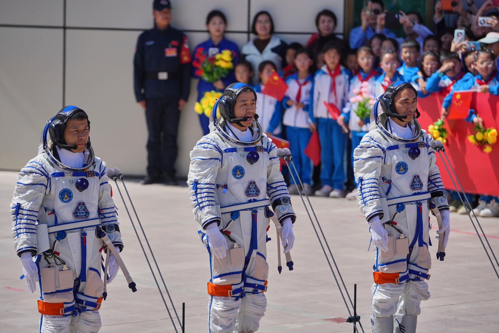 Chinese astronaut for the Shenzhou 20 mission, Chen Dong, center, speaks next to his comrades Chen Zhongrui, right, and Wang Jie as they attend a send-off ceremony for their manned space mission at the Jiuquan Satellite Launch Center in northwestern China, Thursday, April 24, 2025. (AP Photo/Andy Wong)