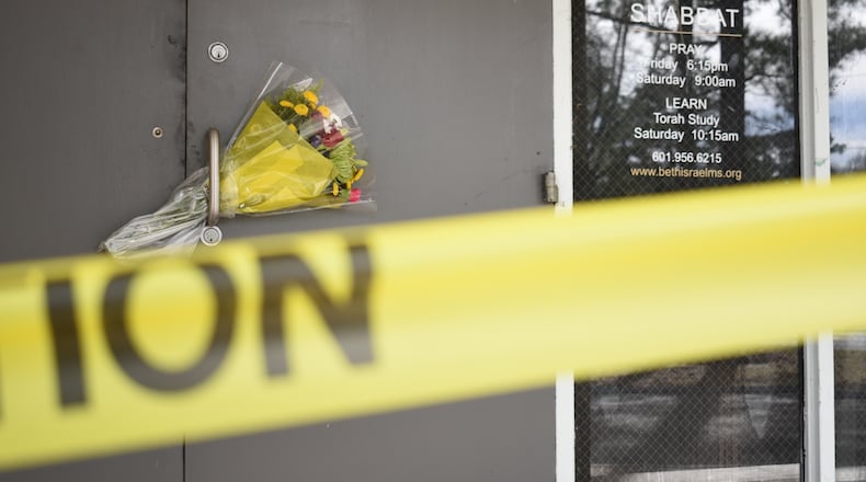 Caution tape and flowers cover the entrance to the Beth Israel Congregation, a synagogue that was set on fire early Saturday morning, on Monday, Jan. 12, 2026, in Jackson, Miss. (AP Photo/Sophie Bates)