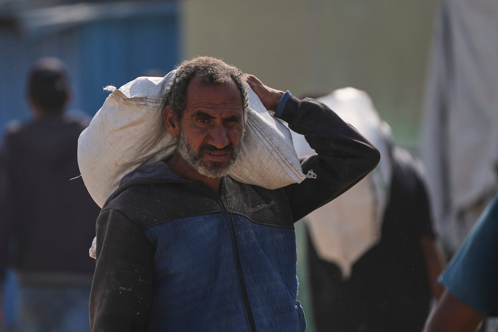 A Palestinian man carries a bag of food after receiving aid from the Gaza Humanitarian Foundation, a U.S.-backed organization approved by Israel, in Khan Younis, southern Gaza Strip, Sunday, June 1, 2025. (AP Photo/Abdel Kareem Hana)