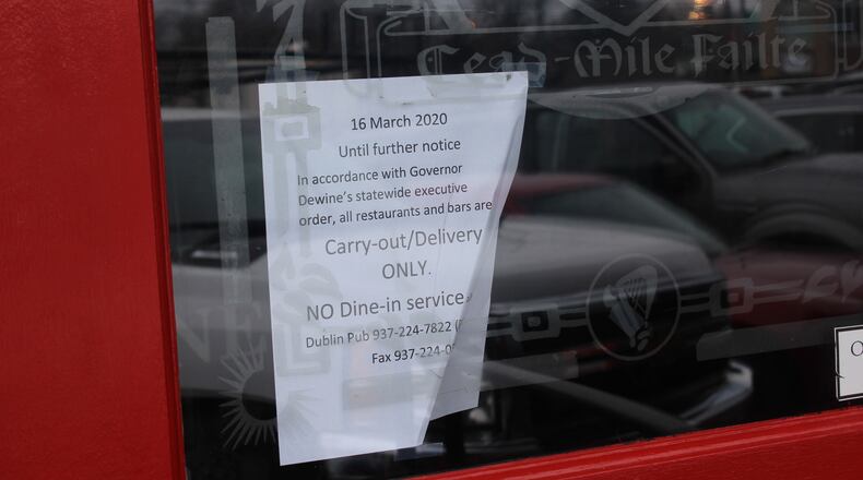 Business owners pushed through or closed shop in the Oregon District in Dayton after Gov. Mike DeWine issued ordered that all restaurants must be carry-out or delivery only. AMELIA ROBINSON/STAFF