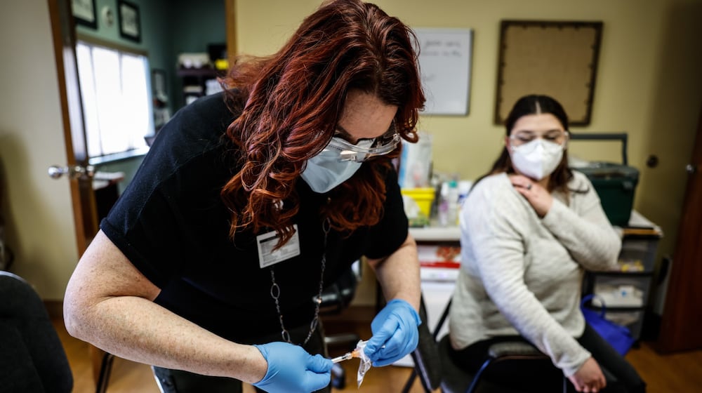 File - Jacinda Snider, a collaborative pharmacist, distributes COVID-19 booster shots at Grafton Oaks Nursing Home on Grafton Ave. Tuesday Jan. 11, 2022. Nearly five years since the start of the COVID-19 pandemic, the virus continues to have a daily impact on Ohioans despite declines in hospitalizations and deaths year over year. JIM NOELKER/STAFF