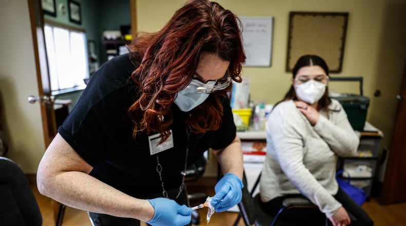 File - Jacinda Snider, a collaborative pharmacist, distributes COVID-19 booster shots at Grafton Oaks Nursing Home on Grafton Ave. Tuesday Jan. 11, 2022. Nearly five years since the start of the COVID-19 pandemic, the virus continues to have a daily impact on Ohioans despite declines in hospitalizations and deaths year over year. JIM NOELKER/STAFF