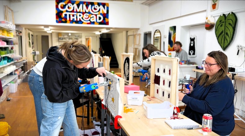 Customers make their own tufted rugs during one of the craft workshops available at the recently opened Common Thread Fiber Art Studio in Xenia, November 21, 2025. DAVID SHERMAN/STAFF