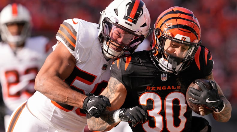 Cincinnati Bengals running back Chase Brown (30) runs the ball as Cleveland Browns linebacker Jordan Hicks, left, defends during the first half of an NFL football game against the Cleveland Browns, Sunday, Dec. 22, 2024, in Cincinnati. (AP Photo/Jeff Dean)