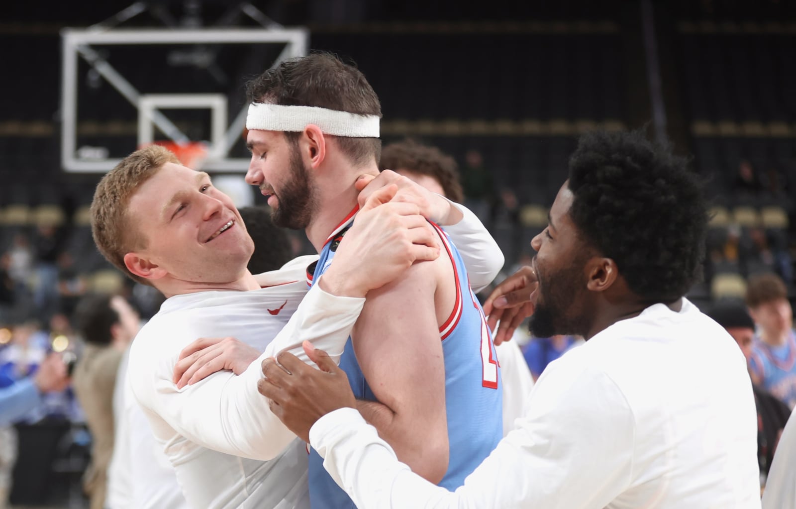 Dayton's Will Maxwell, left, and Makai Grant, right, hug Jacob Conner after a victory against Saint Louis in the semifinals of the Atlantic 10 Conference tournament on Saturday, March 14, 2026, at PPG Paints Arena in Pittsburgh. David Jablonski/Staff