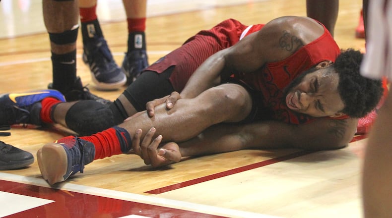 Dayton forward Josh Cunningham grabs his ankle after being injured Tuesday. David Jablonski/Staff